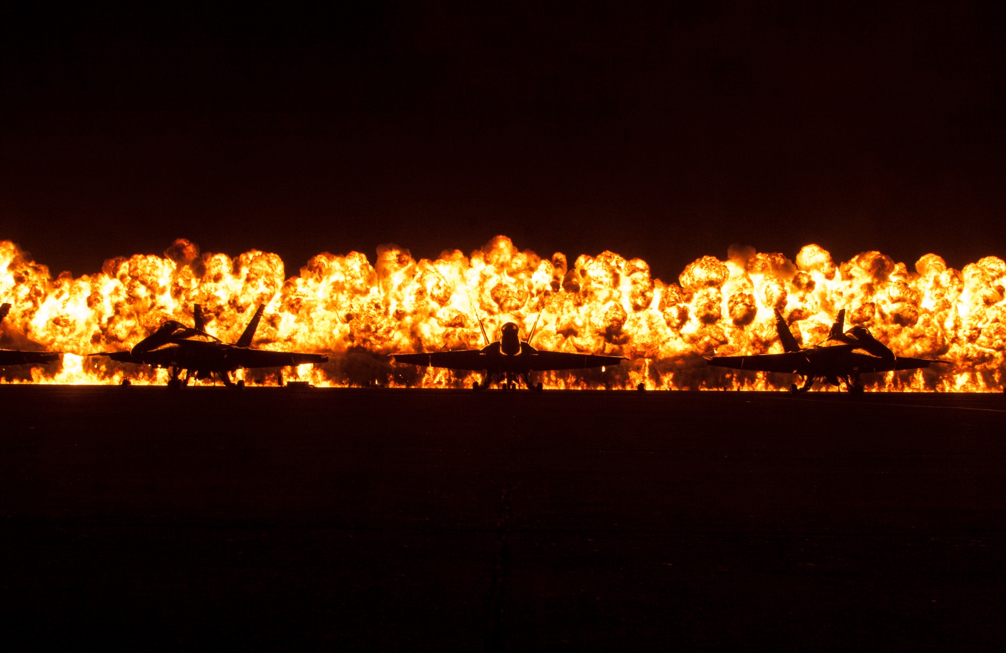 Wall of fire behind Blue Angels aircraft during a night air show at MCAS Miramar